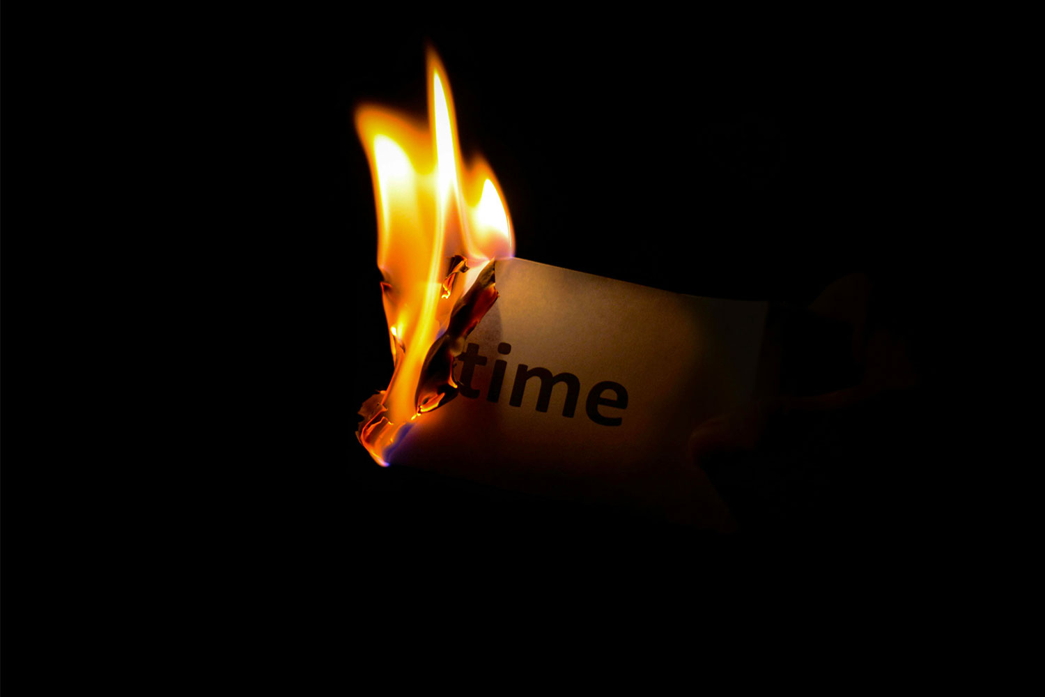 Mot "time" écrit sur un papier qui brûle